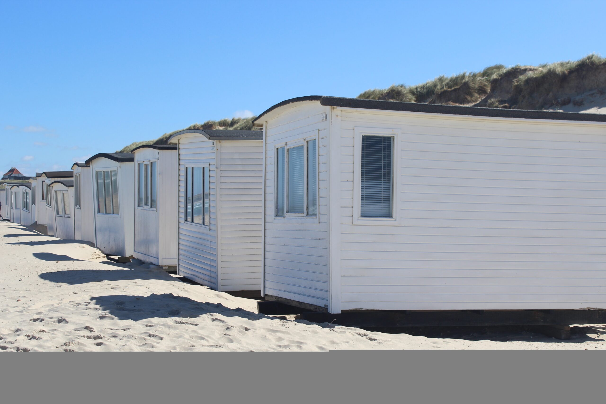 A row of white cabins on the Lokken beach, Denmark